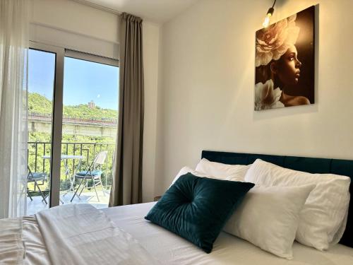a bedroom with a bed with a view of a balcony at Akhdar Apartments in Utjeha