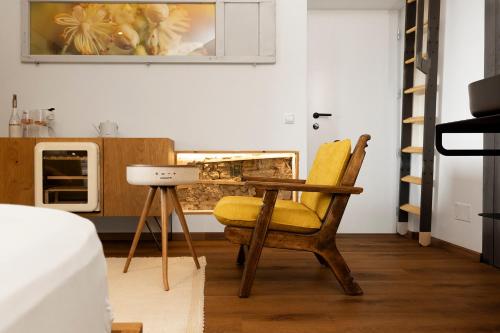 a living room with a yellow chair and a table at Michlhaus nature and suites in Aldino