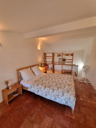 - une chambre avec un lit, un bureau et une chaise dans l'établissement Belle chambre dans maison de charme, à Caunes-Minervois