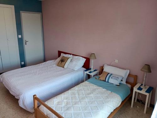 two beds sitting next to each other in a bedroom at Grand appartement vue sur mer in Le Grau-dʼAgde