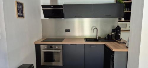 a kitchen with a sink and a stove at "L'appart Idéal" in Deyme
