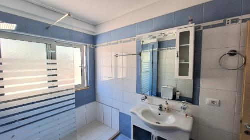 サランダにあるSarandaOfficial Apartmentの青と白のバスルーム(シンク、鏡付)