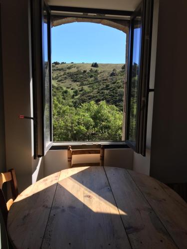 une pièce avec une table et une grande fenêtre dans l'établissement Maison, à Font-Romeu-Odeillo-Via