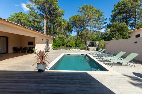 une arrière-cour avec une piscine, des chaises et une maison dans l'établissement Superbe villa, piscine chauffée, jacuzzi, à Lecci