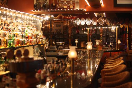 a bar with a lot of bottles of alcohol at 4-Sterne Erlebnishotel El Andaluz, Europa-Park Erlebnis-Resort in Rust