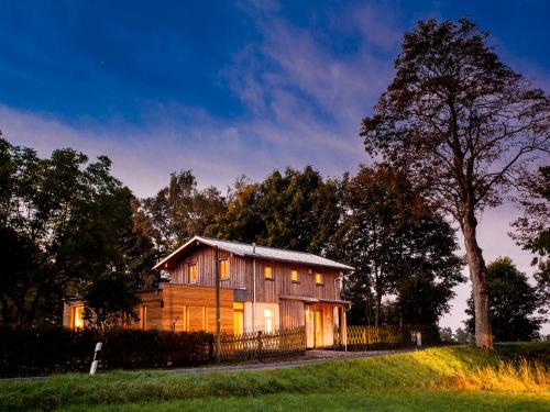 una casa de madera situada en la cima de un frondoso campo verde en Bahnwärterhaus, en Droßdorf