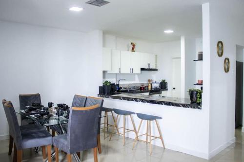 a kitchen with a bar with chairs and a table at Condo In El Murcielago Beach in Manta