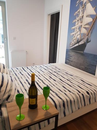 a bottle of wine on a table next to a bed at Morski Apartament 50 m od plaży ApartPark in Świnoujście