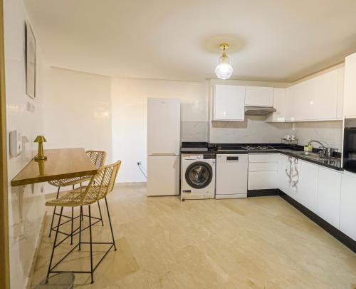 a kitchen with white appliances and a table and chairs at TheCasaEdition - Gueliz Residency in Marrakech