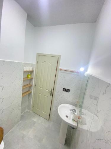 a white bathroom with a sink and a door at طريق صفرو in Fez