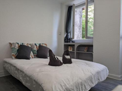 une chambre avec un lit avec deux chaussures dessus dans l'établissement Studio de Tokyo, à Montbéliard