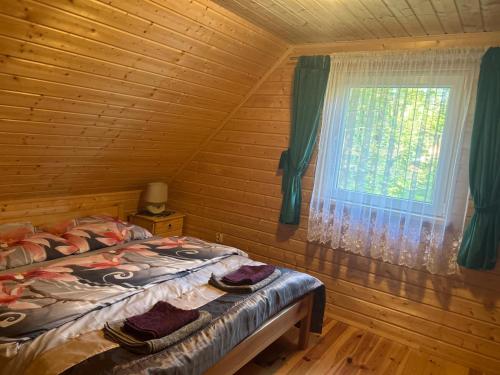 a bedroom with a bed and a window at Domek letniskowy Chrząszczów w Małej Rusi ARIZONA in Kajkowo
