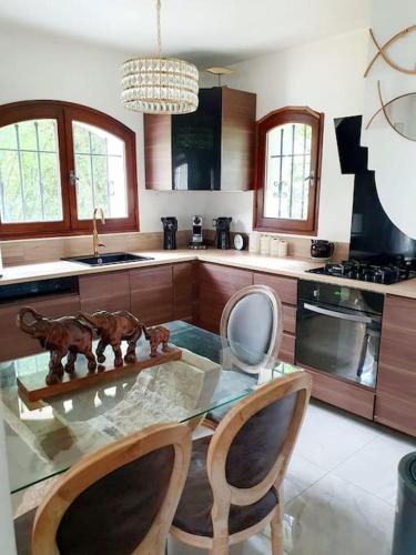 une cuisine avec une table en verre et deux chaises dans l'établissement Maison avec jardin 6 min du RER, à Villiers-sur-Marne