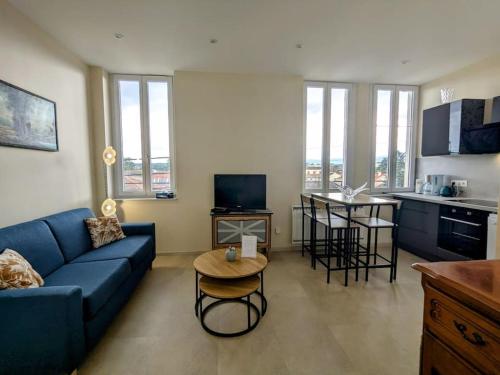 un salon avec un canapé bleu et une cuisine dans l'établissement Parenthèse en centre ville, à Roanne