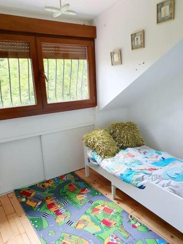 Cette chambre comprend un lit, une fenêtre et un tapis. dans l'établissement Maison avec jardin 6 min du RER, à Villiers-sur-Marne