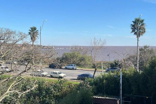 a parking lot with cars parked next to the ocean at Solares de araus, apartamento in Colonia del Sacramento
