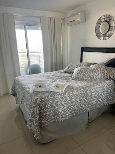a bedroom with a bed with two towels on it at Solares de araus, apartamento in Colonia del Sacramento