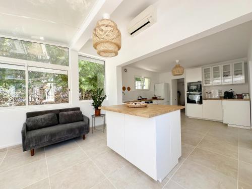 Il comprend une cuisine et un salon avec un bar et un canapé. dans l'établissement La Fincazur! Proche plages, à Six-Fours-les-Plages