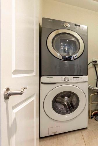 a washer and dryer sitting next to a door at Near Skytrain and QUIET Private Bedroom Ensuite BathRM, Free Wifi & Coffee, Cozy in Burnaby