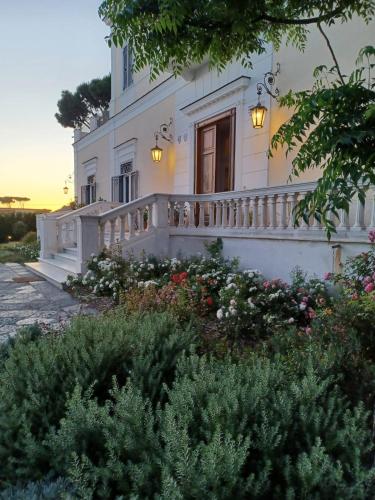 a white house with a balcony and flowers at Villa De Cillis Carafa in Torre del Greco