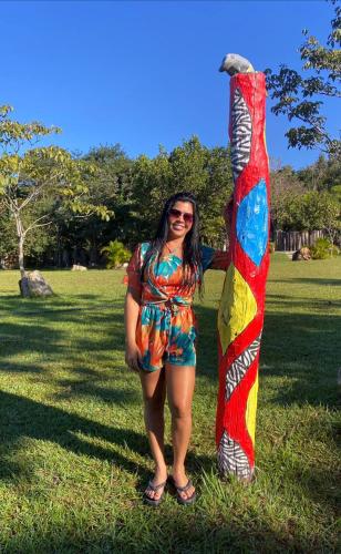 a woman standing in a field holding a kite at Pousada Serra Dourada in Goiás