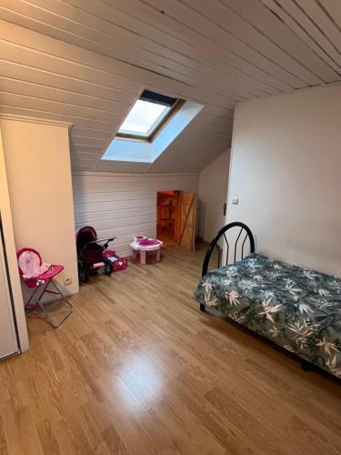 a bedroom with a bed and a skylight at Grande Maison proche Paris 10 12 personnes in Bagnolet