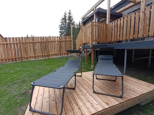 two chairs and a table on a wooden deck at Nature Living Koralm - Neue Chalets auf der Koralpe im Schi- und Wanderparadies in Sankt Stefan im Lavanttal