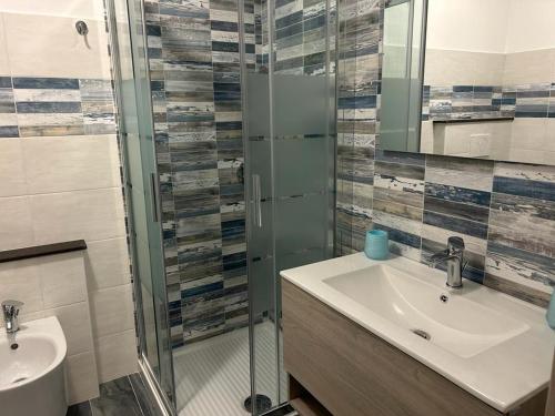 a bathroom with a sink and a glass shower at Rosa dei Venti ROOMS in Abbasanta