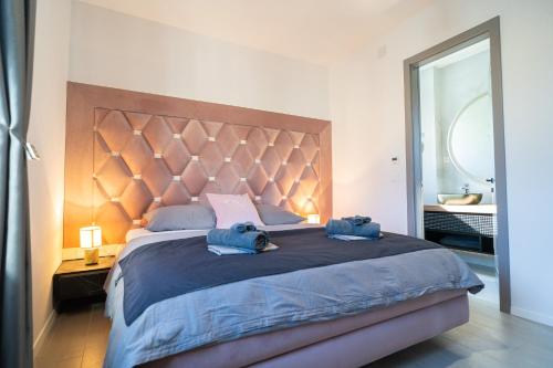 een slaapkamer met een groot bed met 2 blauwe kussens bij La Vista Azure by Belmont Realty in Sukošan