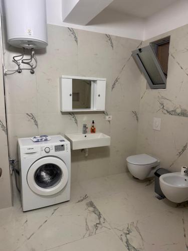 a bathroom with a washing machine and a sink at Adrian Apartment in Orikum