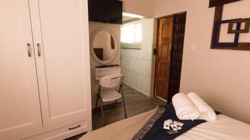 a bedroom with a bed and a sink and a mirror at Rustic Forest Guest House in Cerillio