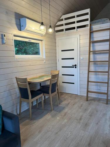 a dining room with a table and chairs and a bunk bed at Domki wypoczynkowe LAS in Śliwice
