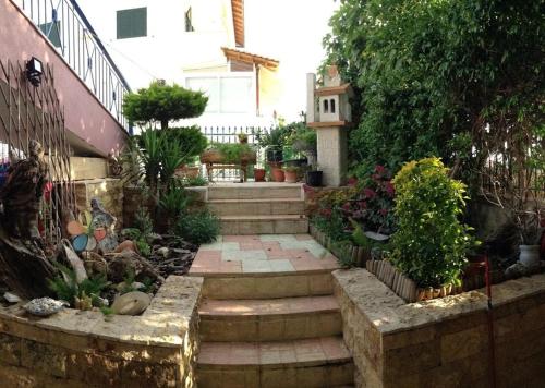 a garden with stairs and plants in front of a house at Roses Apartments in Néa Michanióna