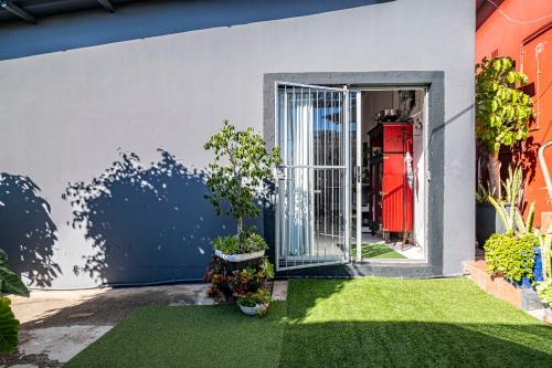 Una puerta abierta a una casa con un patio verde. en Studio47, en Despatch