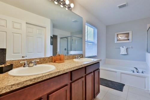 a bathroom with two sinks and a bath tub and a tubermott at Sruthan Kerith in Davenport