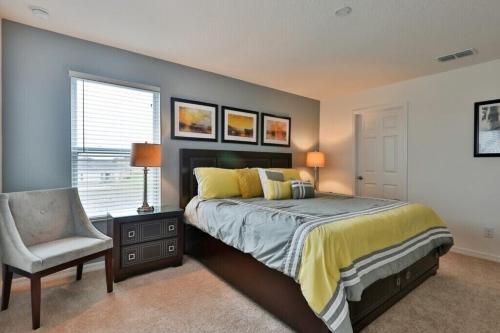 a bedroom with a bed and a chair and a window at Sruthan Kerith in Davenport