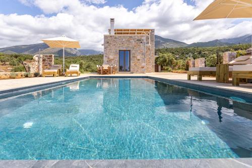 a swimming pool in front of a villa at Lakkos Villas in Kardamili