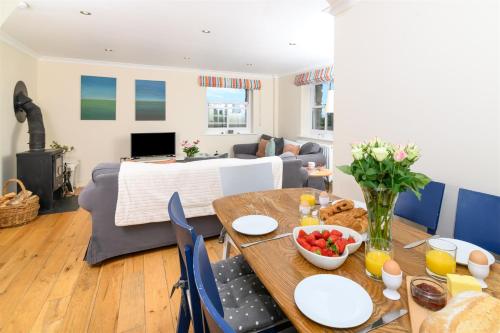 a living room with a table with a bowl of fruit on it at Mousehole Cottage in Penzance