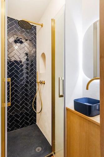 La salle de bains est pourvue d'une douche et d'un lavabo bleu. dans l'établissement Prestige cœur historique, à Toulouse