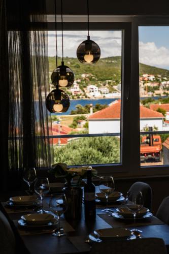 a table with wine glasses and a view of a city at Luxury apartment Barka in Villa with heated pool in Vinišće