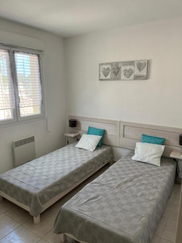 deux lits côte à côte dans une pièce dans l'établissement Corse villa T3 piscine, à Santa-Maria-Poggio