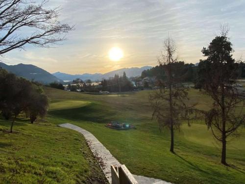 a view of a golf course with the sun setting at Wanaka Springs Lodge in Wanaka