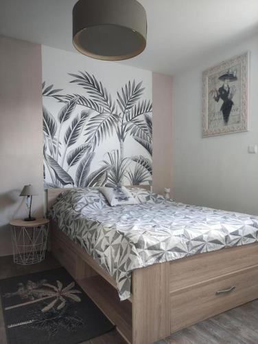 une chambre avec un lit avec un papier peint tropical dans l'établissement Gîte avec vue sur Mont Saint Michel, à Lolif