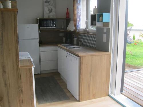 une cuisine avec un évier et un réfrigérateur dans l'établissement Gîte avec vue sur Mont Saint Michel, à Lolif