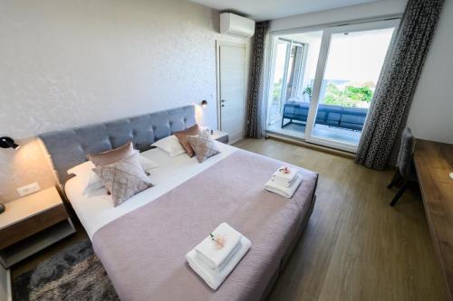 a bedroom with a large bed with two towels on it at Luxury apartment Barka in Villa with heated pool in Vinišće