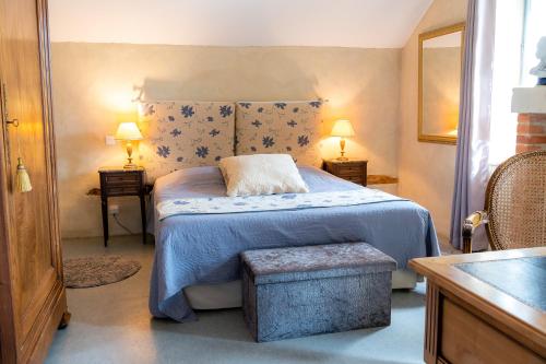 a bedroom with a bed with a blue blanket and two lamps at Chambres d'Hôtes Le Clos des 3 Rois in Thouarcé