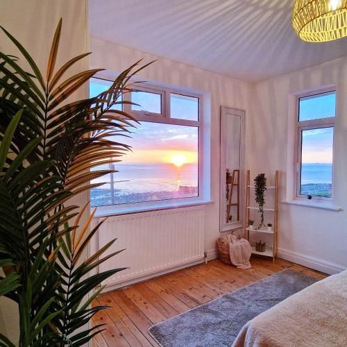 a room with a window with a view of the sunset at Stunning Beachfront House, Herne Bay, Kent in Kent