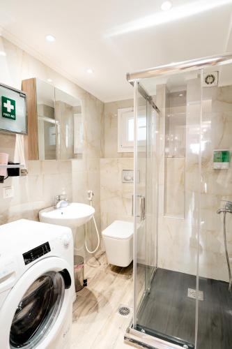 a bathroom with a washing machine and a sink at Diamond & Pearl Studios in Perea