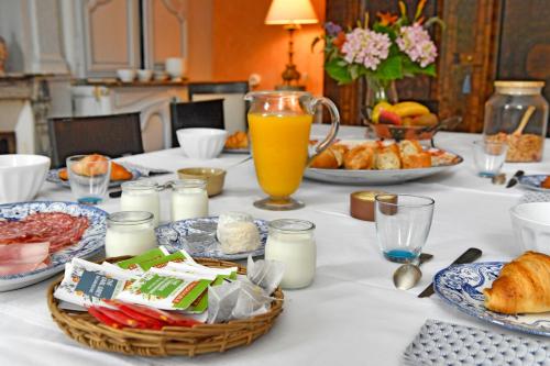une table avec des aliments pour le petit-déjeuner et un pichet de jus d'orange dans l'établissement Le nid de Dany, à Cosne Cours sur Loire
