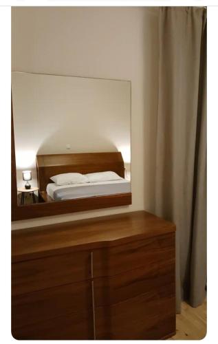 a mirror on a dresser with a bed in a bedroom at Simple and Relaxing House! in Kalamata